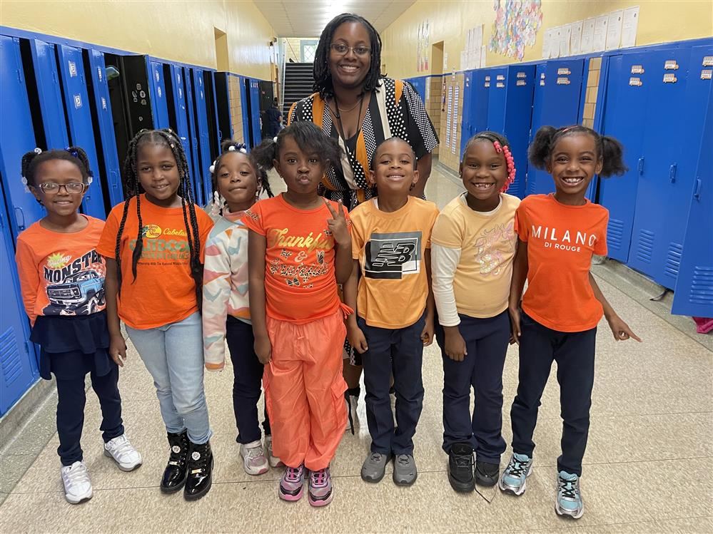  staff and students dressed in orange standing up to no bullying
